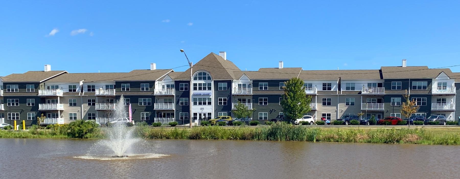 a fountain in a lake in front of a building